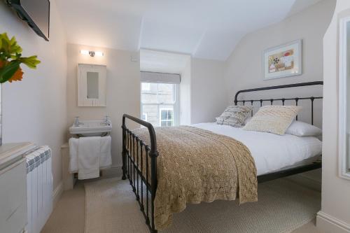 a bedroom with a bed and a sink in it at Anchorage Guest House, St Ives in St Ives