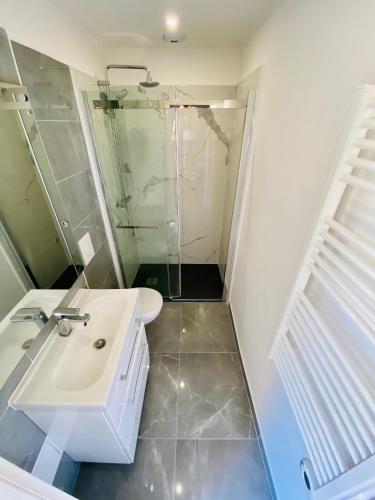 une salle de bain avec un lavabo blanc et une douche dans l'établissement Lovely Apartment Heart of Golden Square Fiber Wifi, à Nice