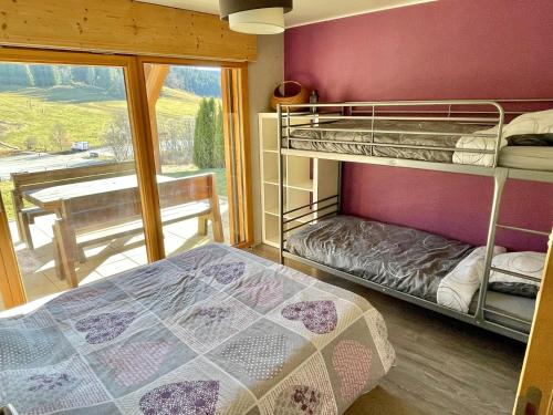 1 Schlafzimmer mit 2 Etagenbetten und einem Balkon in der Unterkunft Gîte avec terrasse et belle vue - ChaletNelda com in Lamoura