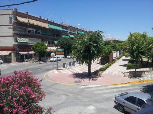 an empty street in a city with a tree at Hotel La Curva in Albolote