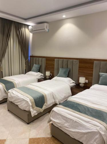 1 dormitorio con 2 camas y 2 mesas con lámparas en ديار الأحبة للوحدات السكنية المفروشة, en Sakaka