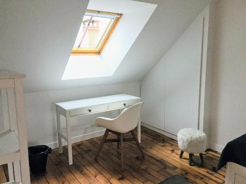 a desk and a chair in a room with a skylight at Bienvenue chez l'habitant in Provins