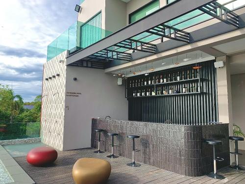 a bar with stools in front of a building at The Poem Hotel in Mae Pim