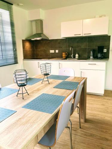 a kitchen with a wooden table and chairs at Vakantiehuis Ervedriestreek in Den Ham
