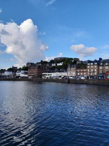 a large body of water with buildings and houses at Pier View Apartment in Oban