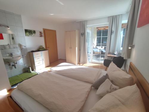 a bedroom with a large white bed and a sink at Apart Bella Cascata in Kappl