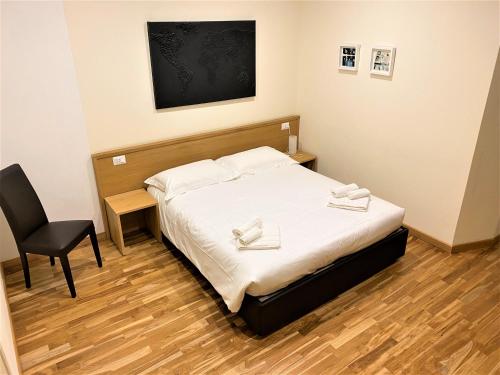 a small bedroom with a bed and a chair at Hotel Trieste in Morbegno