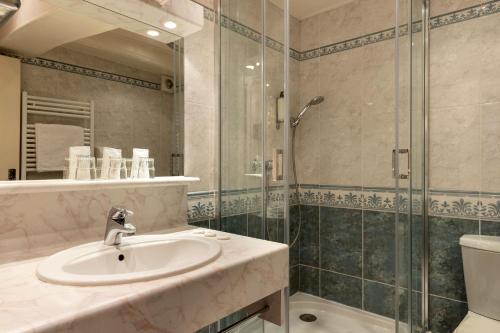 a bathroom with a sink and a shower at Hotel Le Dauphin in Honfleur