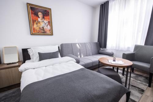 a hotel room with a bed and a couch at Vila Greta by Hotel Ramonda in Rtanj