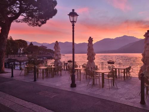 a group of tables and chairs and a street light with a sunset at Domus Alba Lenno in Lenno