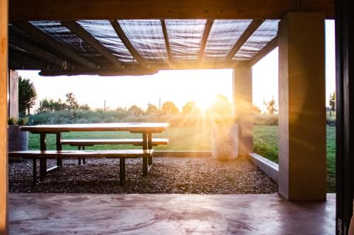 a picnic table in a pavilion with the sun setting at The Aloes Farm - The Studio & The Gallery in Hilton