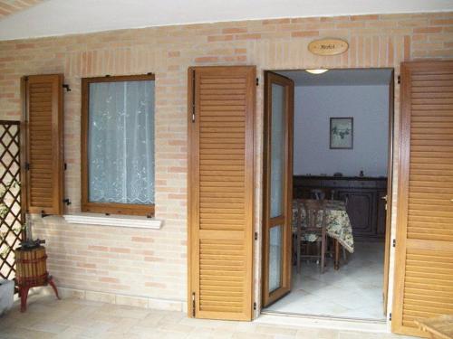 モンテファルコにあるLa Collina Del Sagrantinoの煉瓦の壁と2つのドアがある部屋