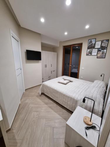 Schlafzimmer mit einem Bett, einem Tisch und einem TV in der Unterkunft Nonno Umberto Apartments in Pompei