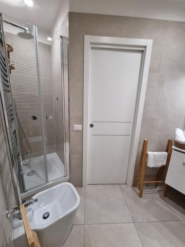 ein Bad mit einer Dusche und einem weißen Waschbecken in der Unterkunft Nonno Umberto Apartments in Pompei