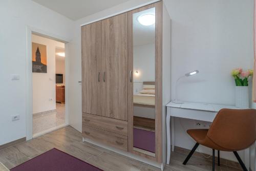 a bedroom with a desk and a closet at Apartment GAGULA with jacuzzi in Trogir