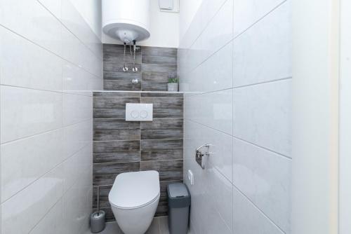 a white bathroom with a toilet and a sink at Apartment GAGULA with jacuzzi in Trogir