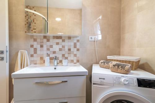 a bathroom with a sink and a washing machine at Apartment GAGULA with jacuzzi in Trogir