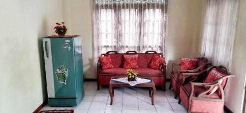 a living room with a red couch and a refrigerator at Chao Beach Villa in Ahangama