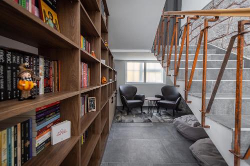 a hallway with shelves of books with two chairs at Vila Greta by Hotel Ramonda in Rtanj