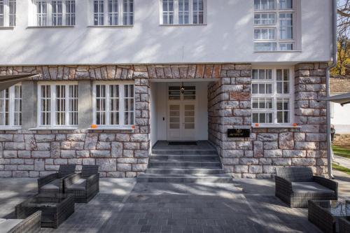 a stone building with benches in front of it at Vila Greta by Hotel Ramonda in Rtanj