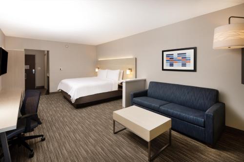 a hotel room with a bed and a couch at Holiday Inn Express & Suites Ft Myers Beach-Sanibel Gateway by IHG in Fort Myers Beach