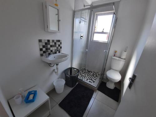 a bathroom with a shower and a toilet and a sink at Covenant Place in Cape Town