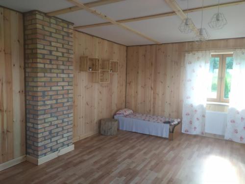 a room with a brick wall and a bed in it at Przy Trójstyku in Dubeninki
