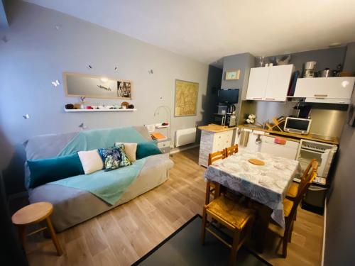 a living room with a couch and a table at Le Navarre, charmant T2 familial bien équipé en rdc , en centre-ville Cauterets in Cauterets