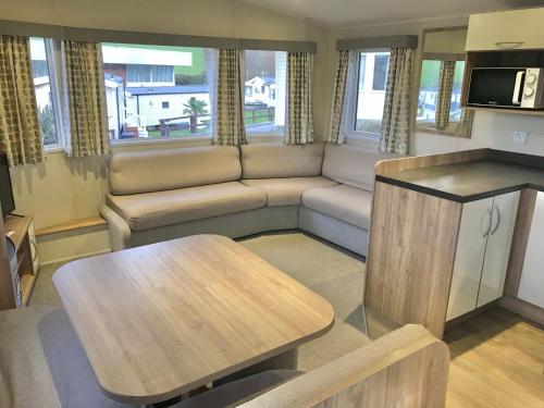 a living room with a couch and a table at NB12 Entire Caravan - Newquay in Newquay Bay Resort