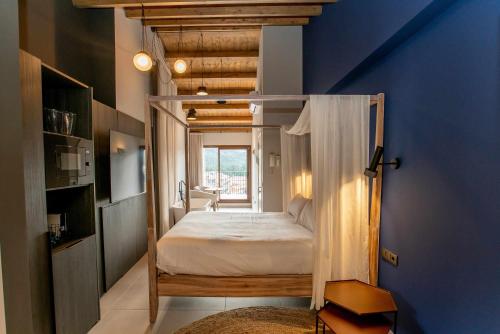 ein Schlafzimmer mit einem Himmelbett in einem blauen Zimmer in der Unterkunft Mochoruralhome matarraña suite in Beceite