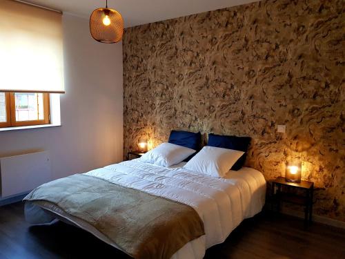 ein Schlafzimmer mit einem großen Bett mit blauen Kissen in der Unterkunft Le Petit Relais de Launois in Launois-sur-Vence