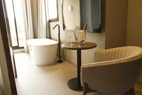 a room with a tub and a table and a chair at Mochoruralhome ulldemo suite in Beceite
