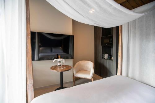 a bedroom with a bed and a chair and a table at Mochoruralhome ulldemo suite in Beceite
