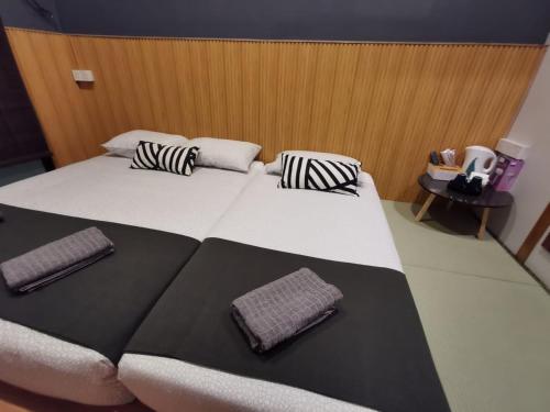 a large bed in a room with two pillows on it at Tatami D'Tepi Laut - PANGKOR ISLAND in Pangkor