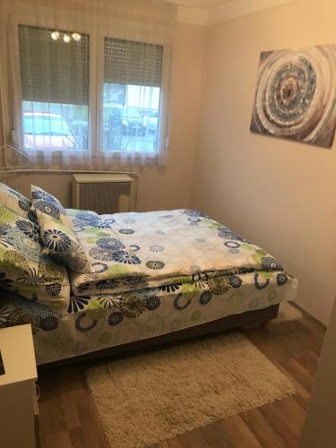 een slaapkamer met een bed met een quilt bij Menta apartman in Szolnok
