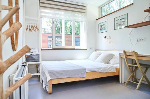 een slaapkamer met een bed en een raam bij The Amsterdam Houseboat Family - de Pijp in Amsterdam