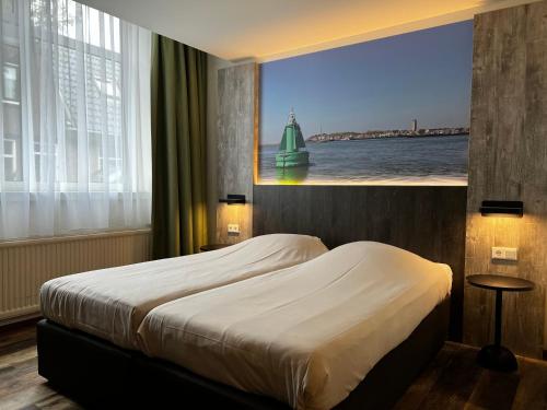 a bedroom with a bed and a large window at Hotel Nap in West-Terschelling