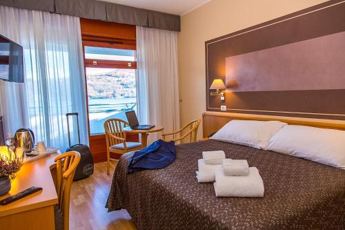 une chambre d'hôtel avec un lit et des serviettes. dans l'établissement Hotel Chalet del Lago, à Avigliana