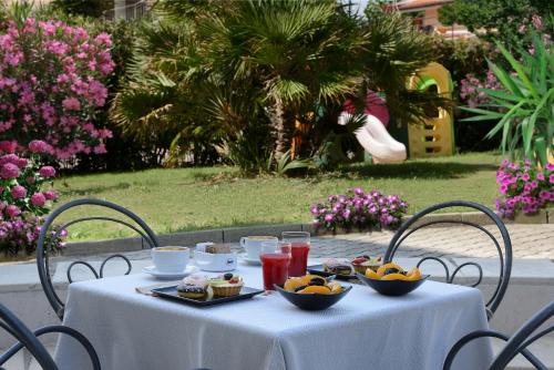 una mesa blanca con tazones de comida. en Hotel Nuovo Diana, en Senigallia