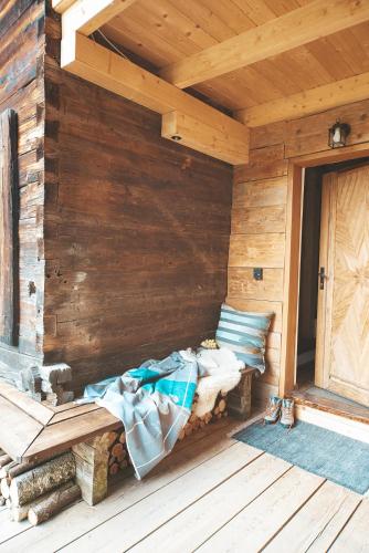 a porch of a wooden cabin with a bench and pillows at Chalet Weiberle Hochschwab in Etmissl