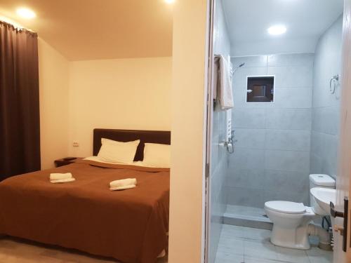 a bedroom with a bed and a shower and a toilet at Cottage Panorama in Bakuriani