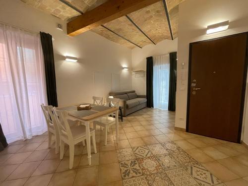 a dining room with a table and chairs and a couch at B&B Sacca in Lanciano