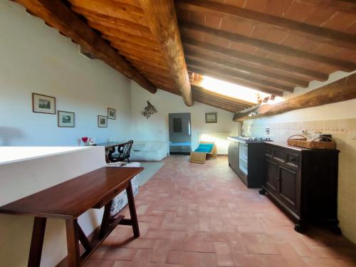 a large kitchen with wooden ceilings and a table at Palazzo Bianciardi Attico in Castellina in Chianti