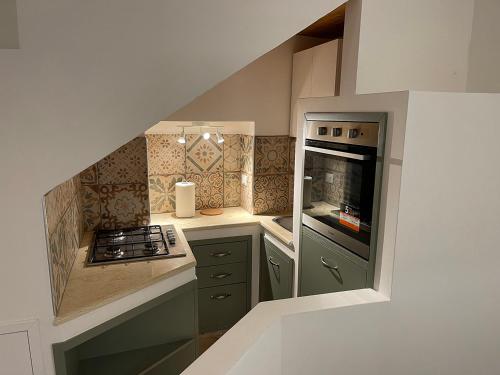a small kitchen with green cabinets and a stove at B&B Sacca in Lanciano
