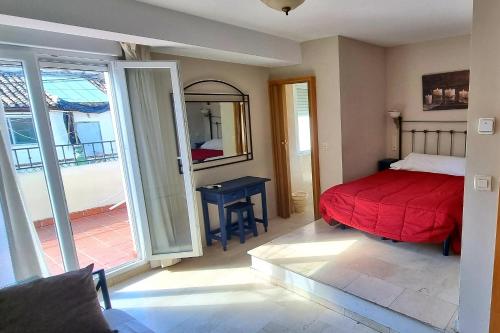 a bedroom with a red bed and a sliding glass door at Hostal El Olivo in Granada