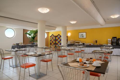 Un comedor con mesas y sillas con comida sobre ellas. en Hotel Nuovo Diana, en Senigallia