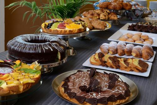una mesa llena de diferentes tipos de pasteles y repostería en Hotel Nuovo Diana, en Senigallia