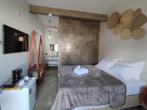 1 dormitorio con 1 cama grande y TV en De Ventto Em Popa - São Miguel do Gostoso RN en São Miguel do Gostoso