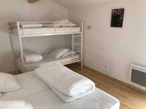 Zimmer mit 2 Etagenbetten mit weißer Bettwäsche in der Unterkunft Essai de chaille in Surgères
