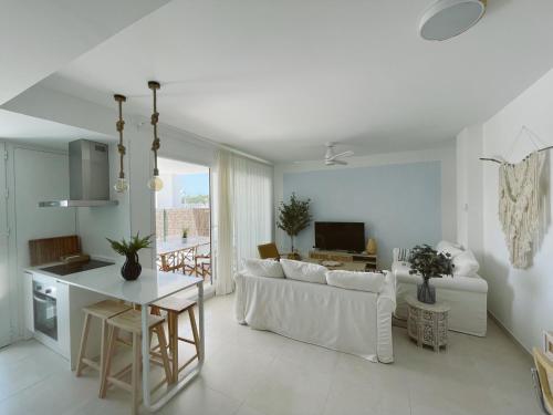 Costa Ballena - Playa Azul Beach House في كوستا بالينا: غرفة معيشة بيضاء مع أريكة بيضاء وطاولة